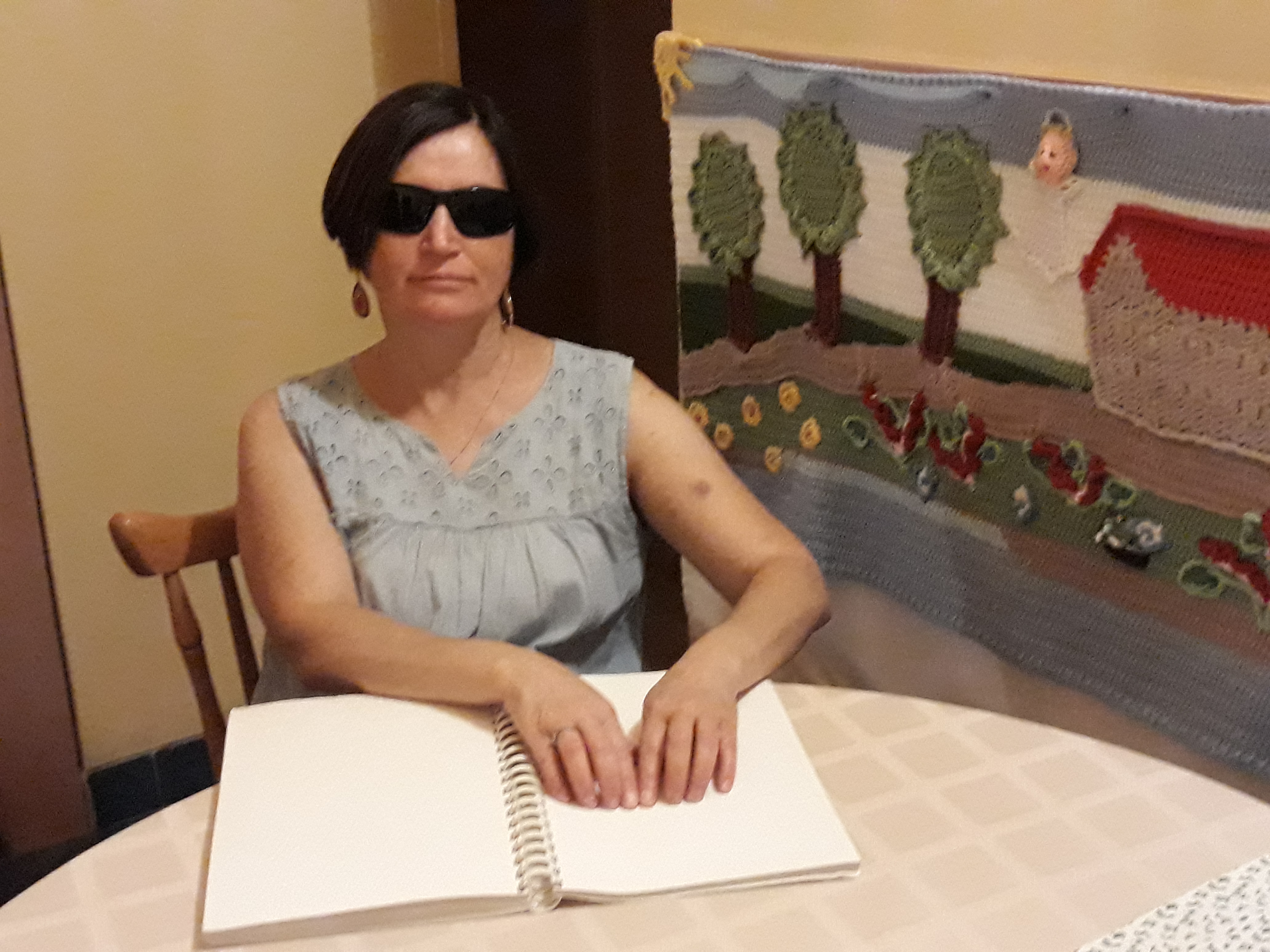Braille írással készült könyvet olvas Marcsi